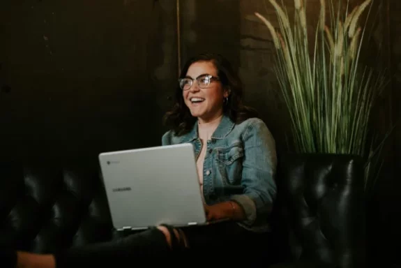 Femme-souriante-travaillant-sur-un-ordinateur-portable-dans-un-espace-de-coworking-chaleureux